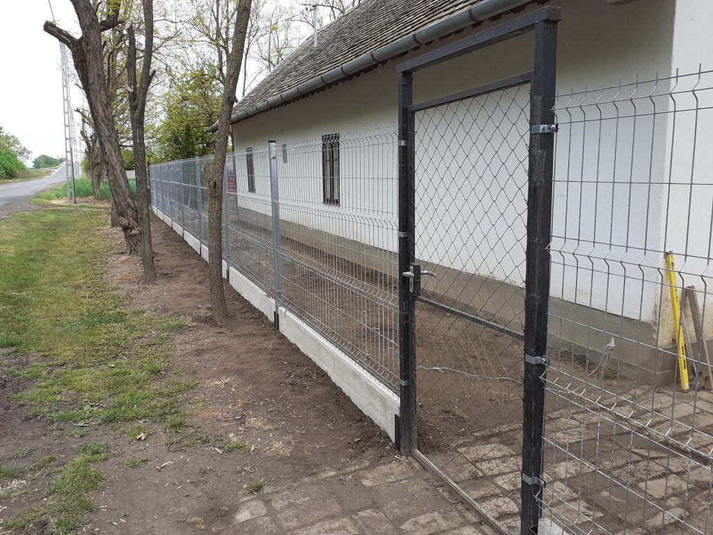 Régi ház frontján 3d táblás kerítés húzódik végig beton alappal