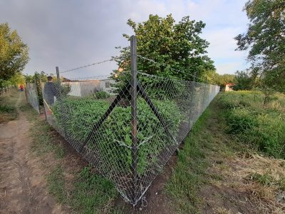 Hobbikert drótkerítéssel és zártszelvényből készült oszlopokkal elkerítve szögesdróttal a tetején.